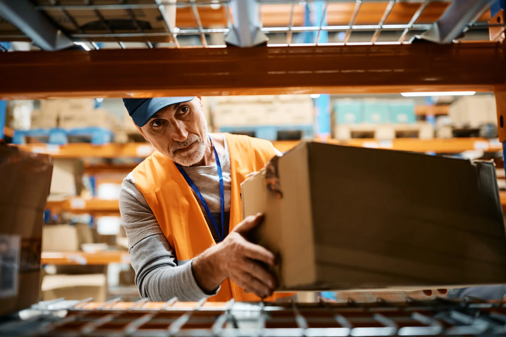 Worker stacking packages on warehouse racks