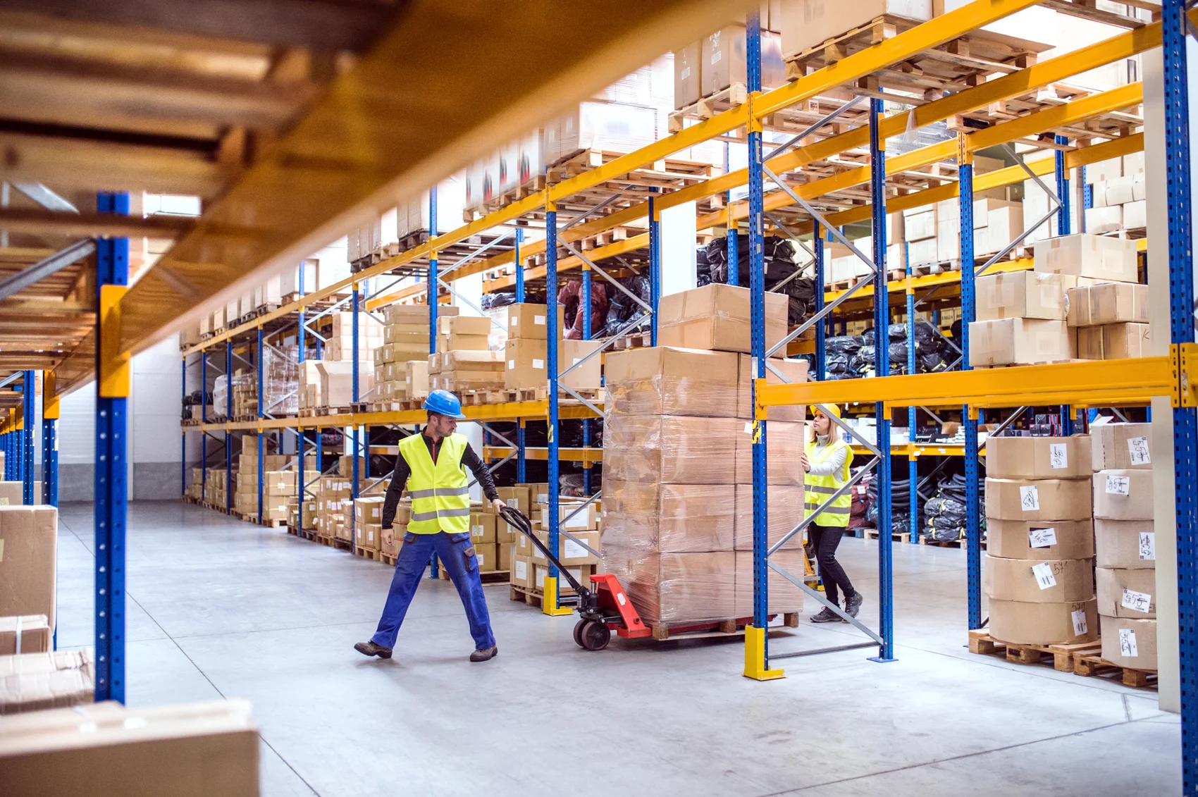 Warehouse workers moving products with a pallet truck