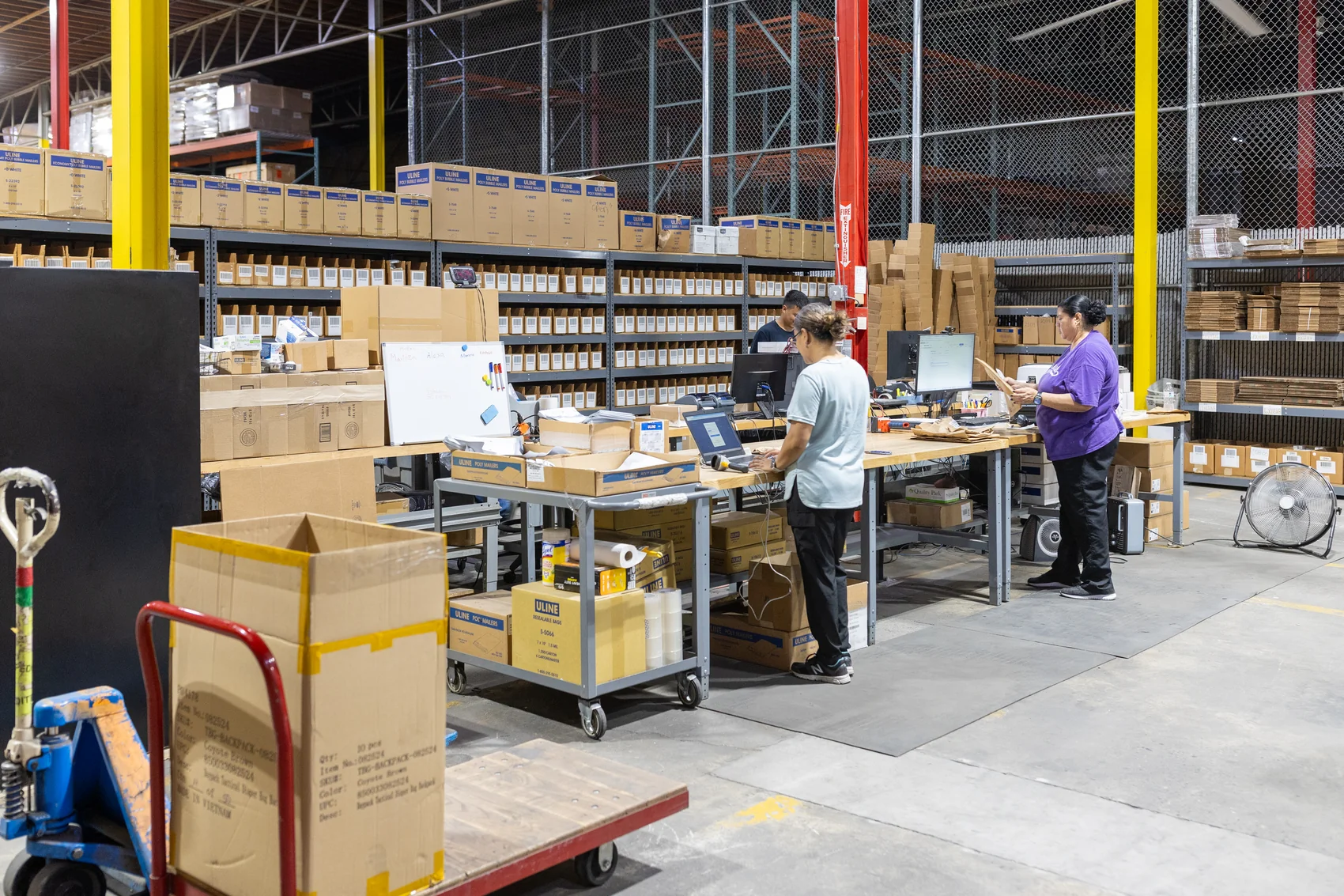 Warehouse employees managing inventory together